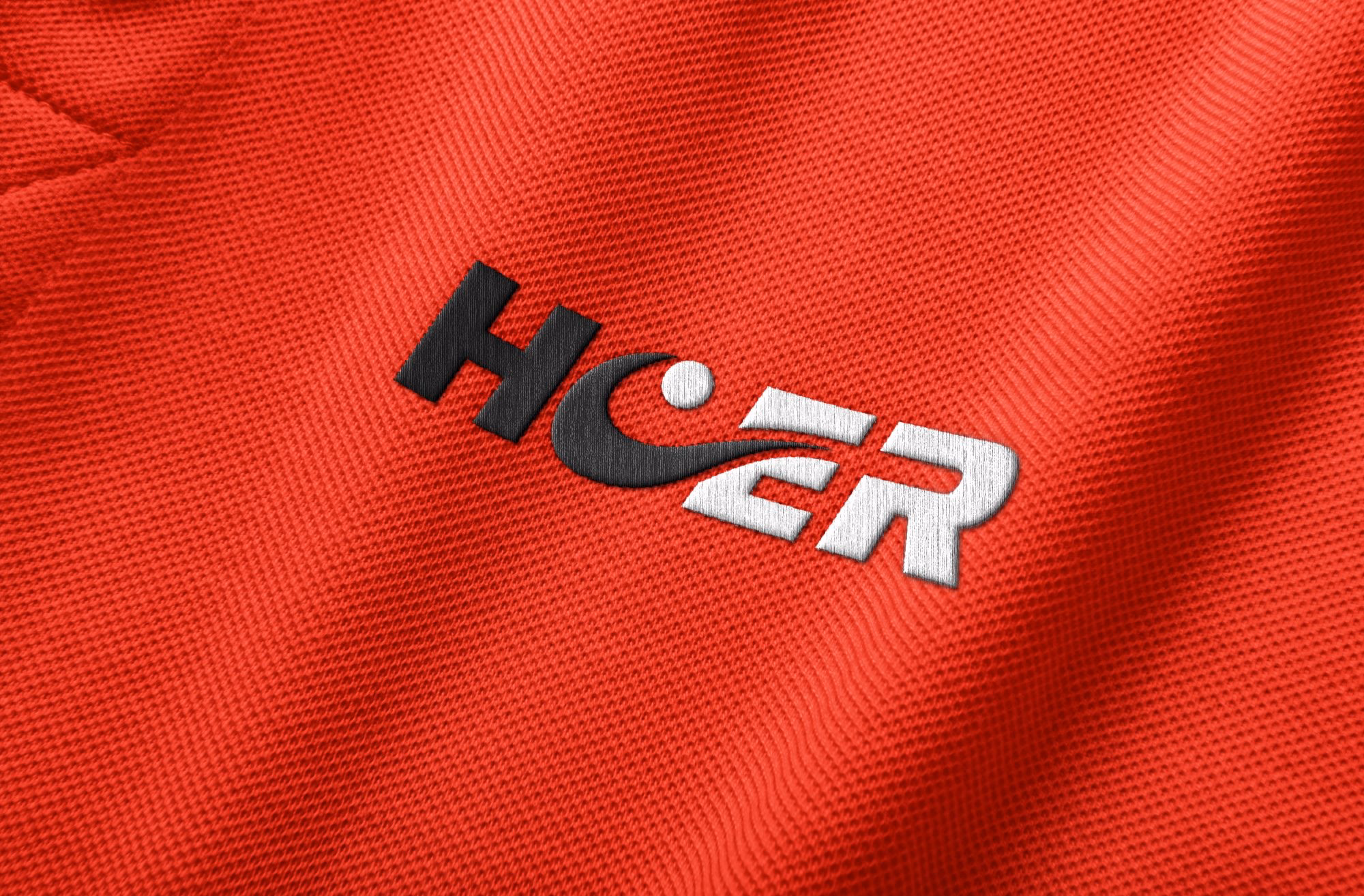 Rotes Sportshirt mit gesticktem schwarzweißem HCER-Logo und Tennisball-Symbol.