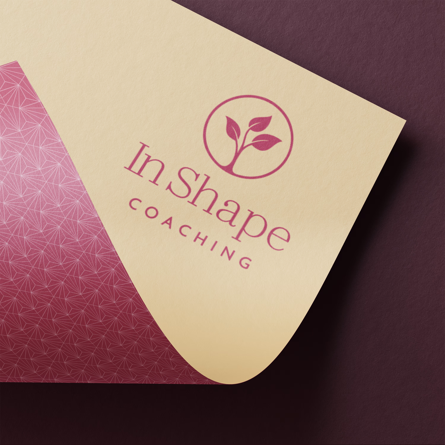 Visitenkarte von "InShape Coaching" mit rosa Pflanzenmotiv und geometrischem Muster auf cremefarbenem Hintergrund.