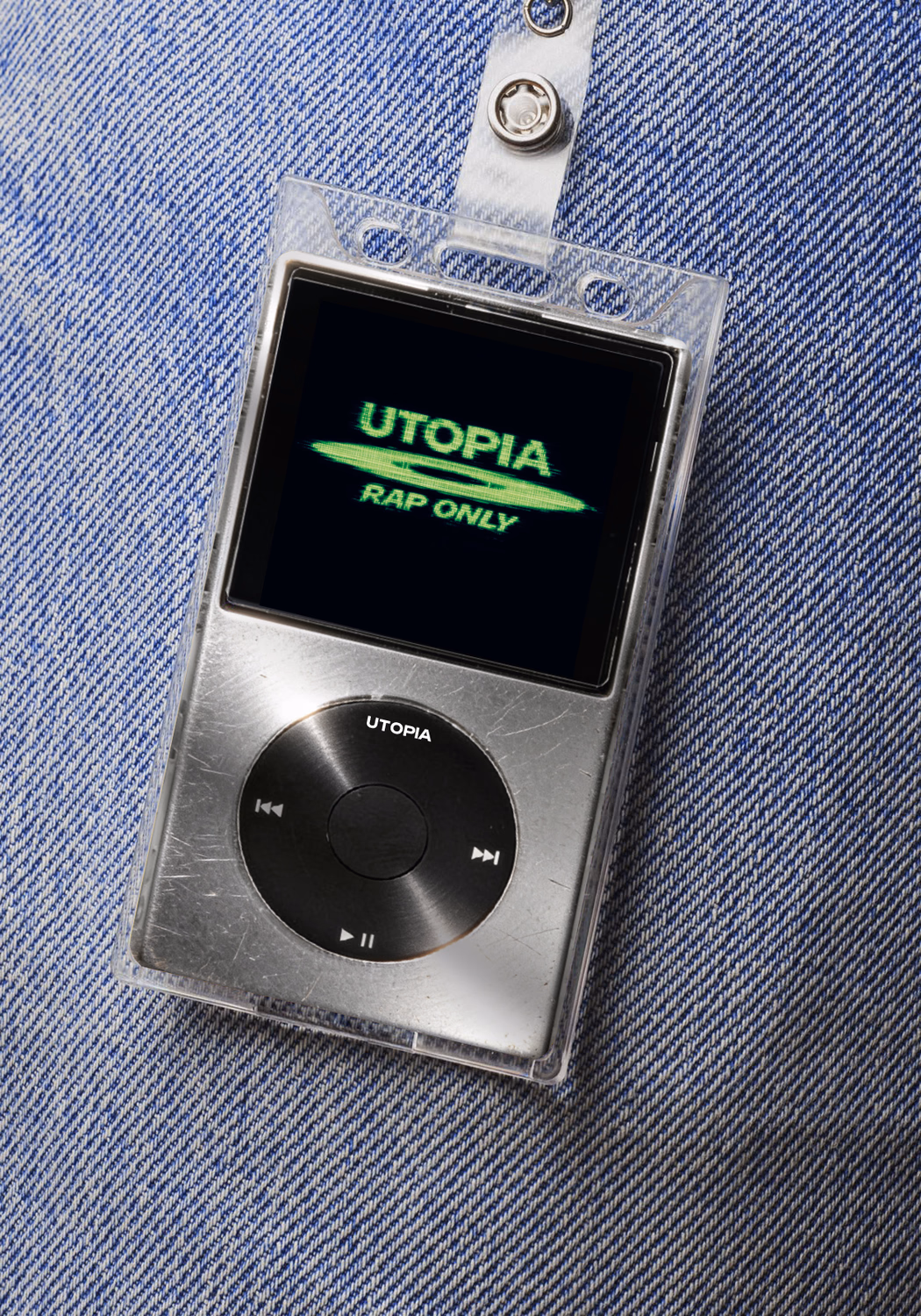 Utopia Rap Only Musik-Player mit silbernem Gehäuse und schwarzem Clickwheel auf blauem Jeansuntergrund.